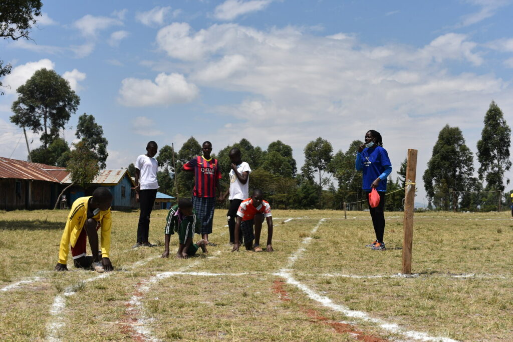 CPI kids ready to race outside on a grassy track.