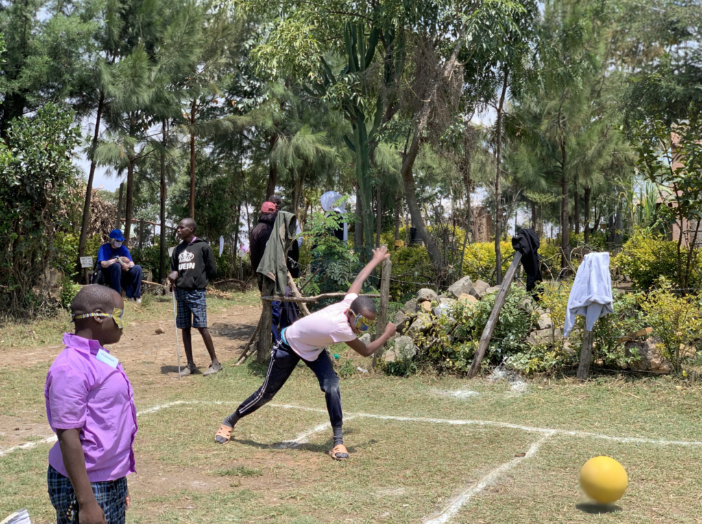 A student throwing a ball to the center of the court, as a crowd gathered to watch.